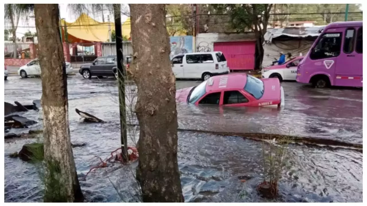 Taxi de CDMX cae a SOCAVÓN provocado por MEGA fuga de agua en calle de Iztapalapa | FOTOS
